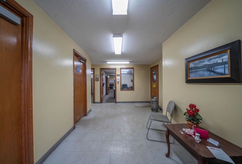 Hallway featuring a textured ceiling and baseboards