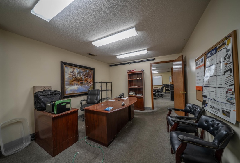 Office space with carpet and a textured ceiling