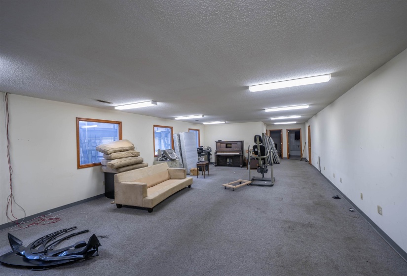 Workout room featuring a textured ceiling, carpet, and baseboards