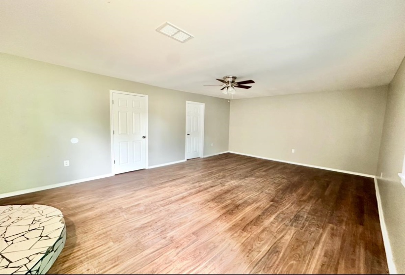 Unfurnished room featuring a ceiling fan, wood finished floors, and baseboards
