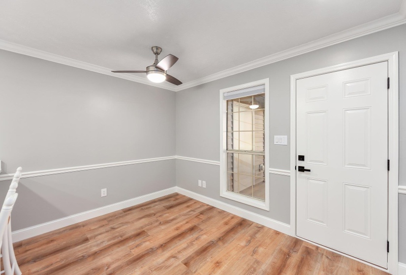Foyer featuring a ceiling fan, crown molding, and light wood-type flooring