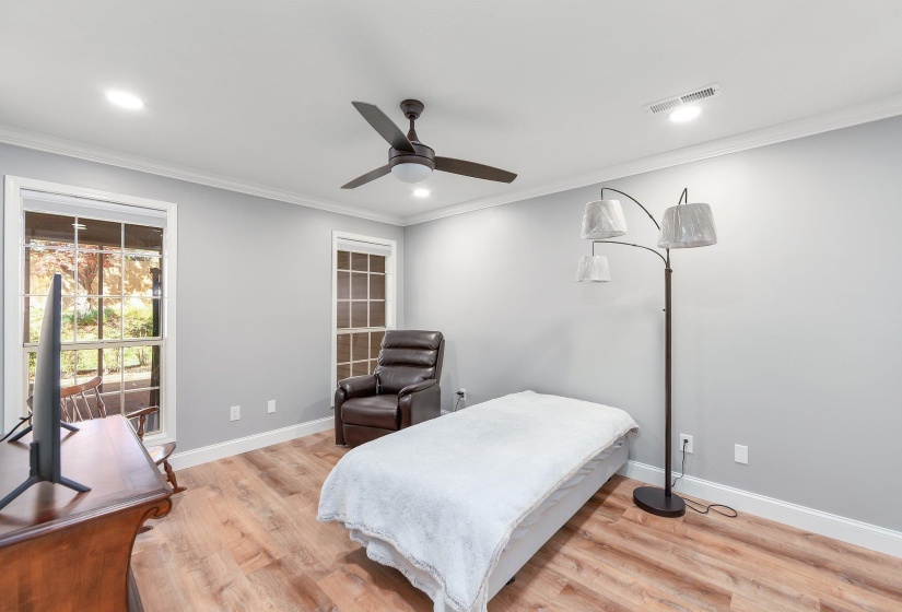 Bedroom with light wood-type flooring, ornamental molding, baseboards, and visible vents