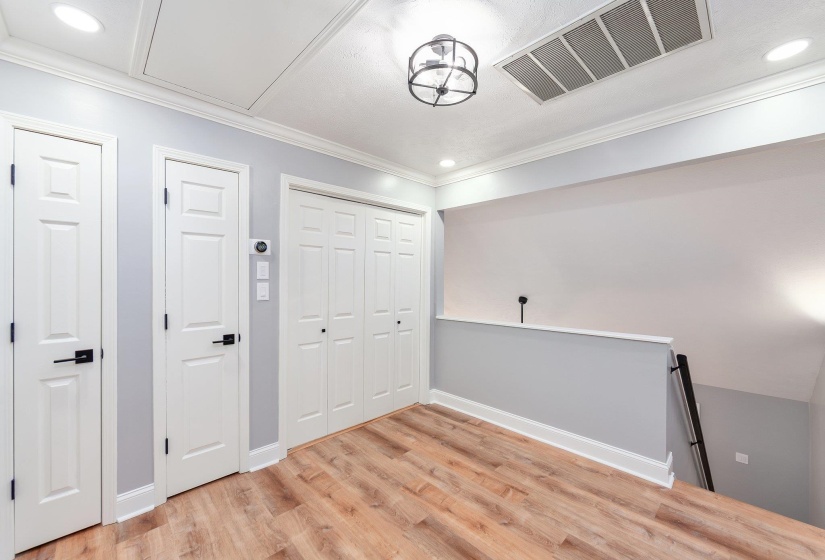 Unfurnished bedroom featuring visible vents, light wood finished floors, baseboards, ornamental molding, and recessed lighting