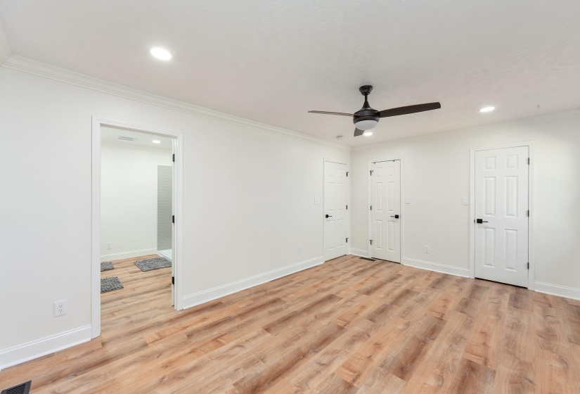 Unfurnished bedroom featuring light wood-style flooring, crown molding, and baseboards