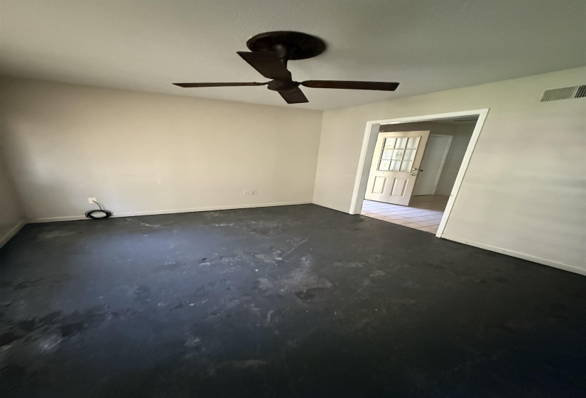 Unfurnished room with ceiling fan, concrete floors, and baseboards