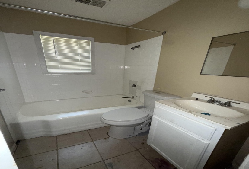 Bathroom with vanity, toilet, shower / bath combination, and tile patterned floors