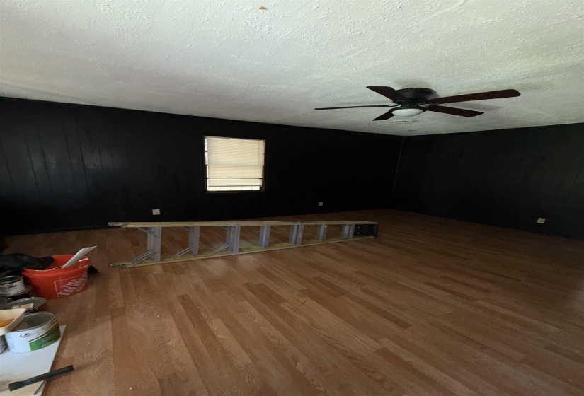 Empty room featuring a textured ceiling, wood finished floors, and ceiling fan