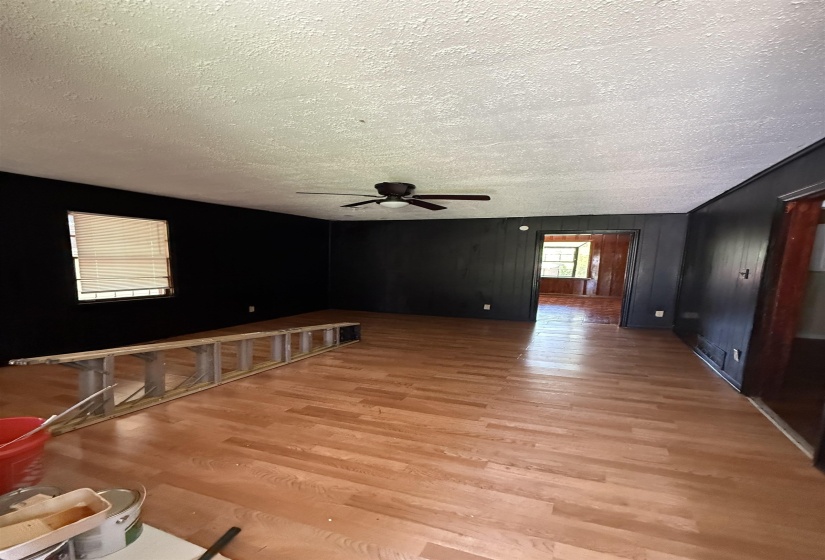 Empty room featuring a textured ceiling, light wood-style floors, and a ceiling fan