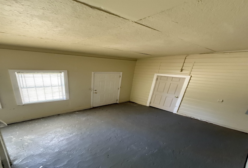 Unfurnished room with a textured ceiling and concrete floors