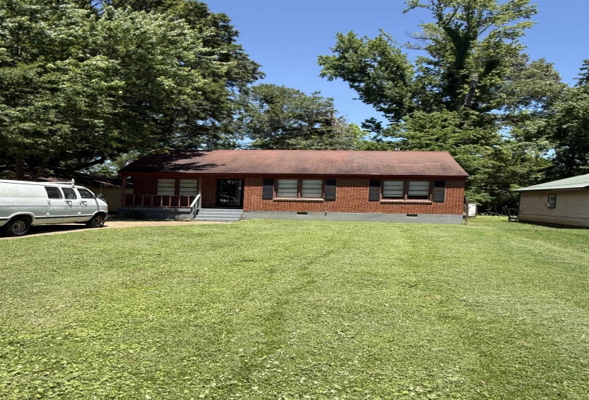 View of front of property featuring a front yard, brick siding, and a porch