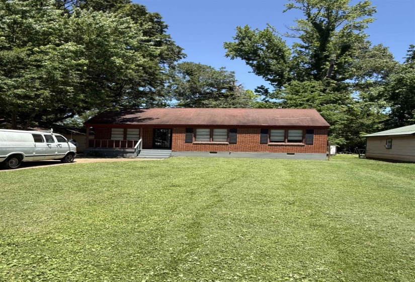View of front of house with a front yard, brick siding, and covered porch