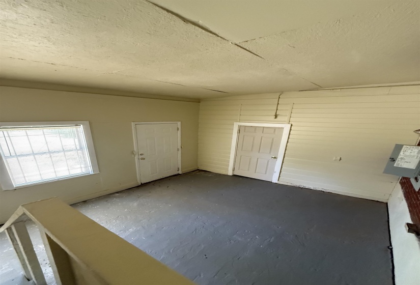 Foyer entrance with a textured ceiling and concrete flooring