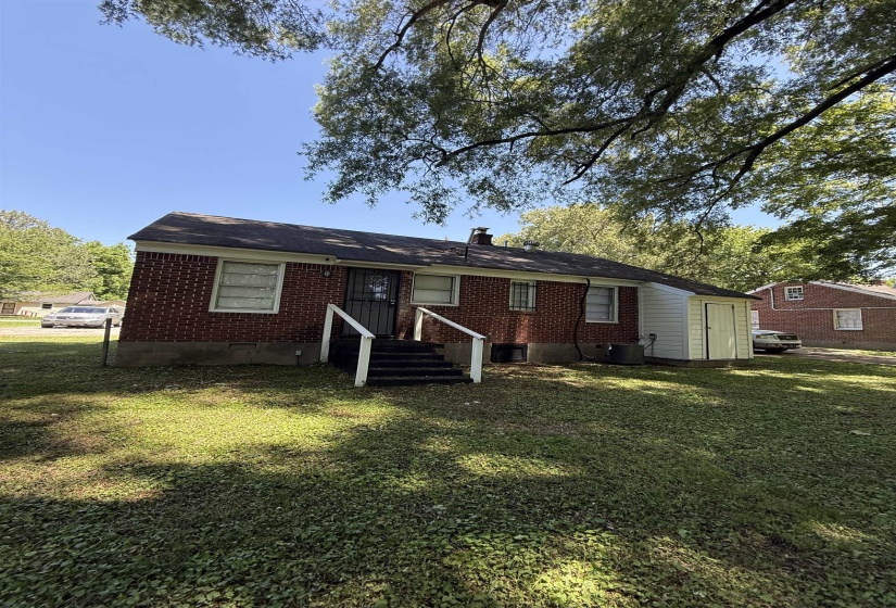 Rear view of property featuring brick siding, a yard, and cooling unit