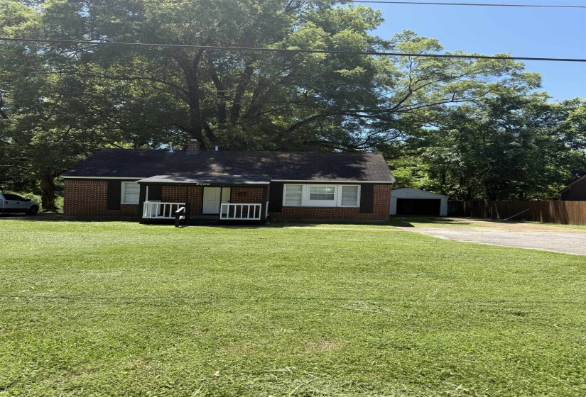 View of front facade with brick siding, driveway, and a garage
