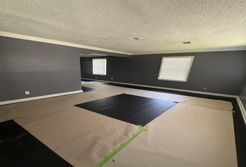 Empty room with crown molding, baseboards, and a textured ceiling