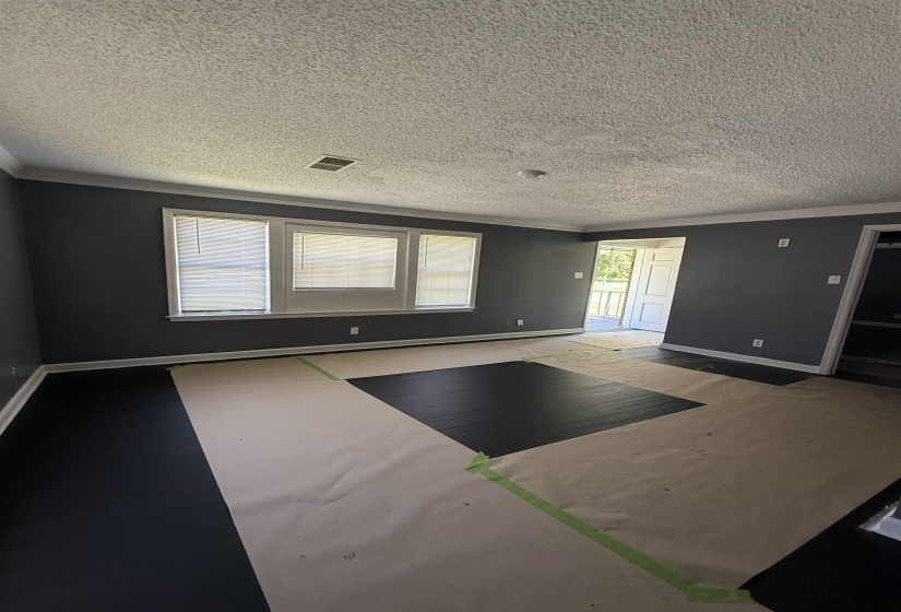 Spare room featuring crown molding, baseboards, and a textured ceiling