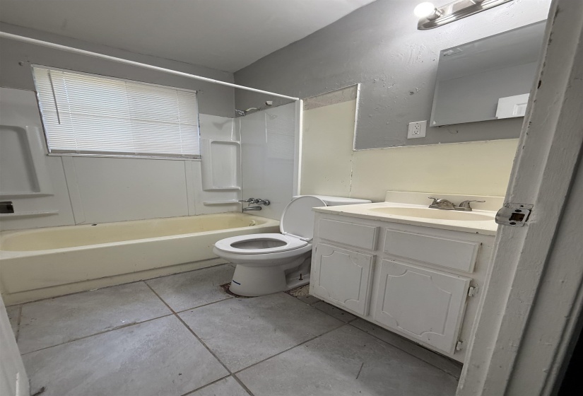Full bath featuring tile patterned floors,  shower combination, vanity, and toilet
