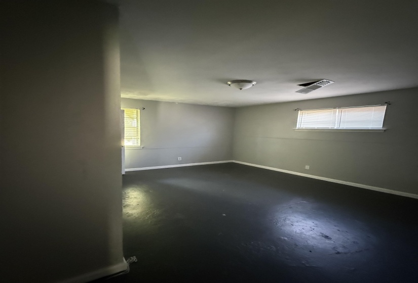 Unfurnished room with concrete flooring and baseboards
