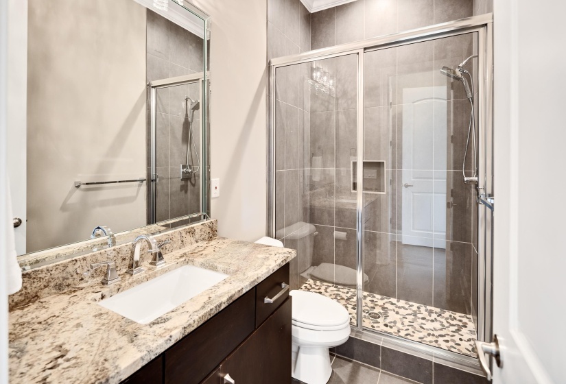 Full bathroom with toilet, vanity, and a shower stall