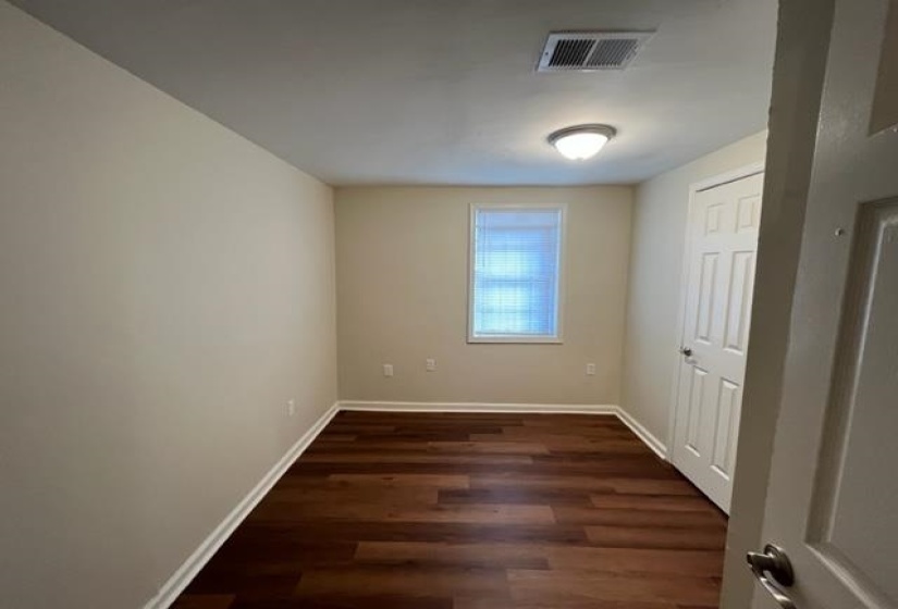 Unfurnished room with dark wood-type flooring and baseboards