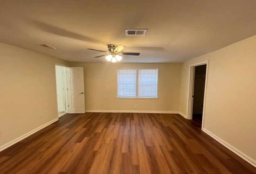 Unfurnished bedroom with dark wood finished floors, baseboards, and a ceiling fan