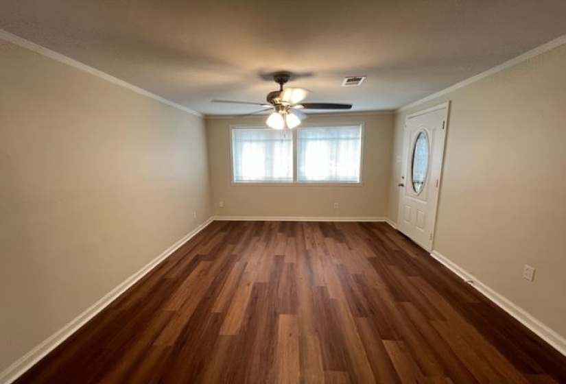 Entrance foyer with dark wood-style floors, crown molding, a ceiling fan, and baseboards