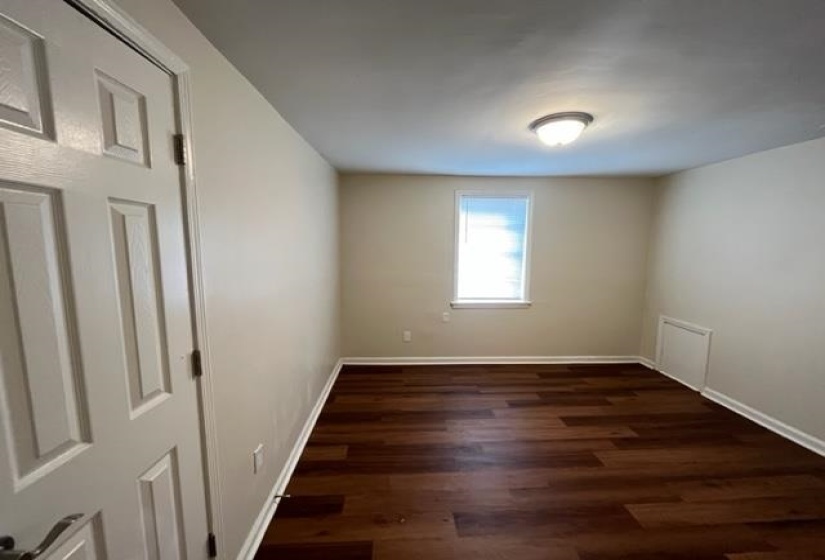Unfurnished room with dark wood-style flooring and baseboards