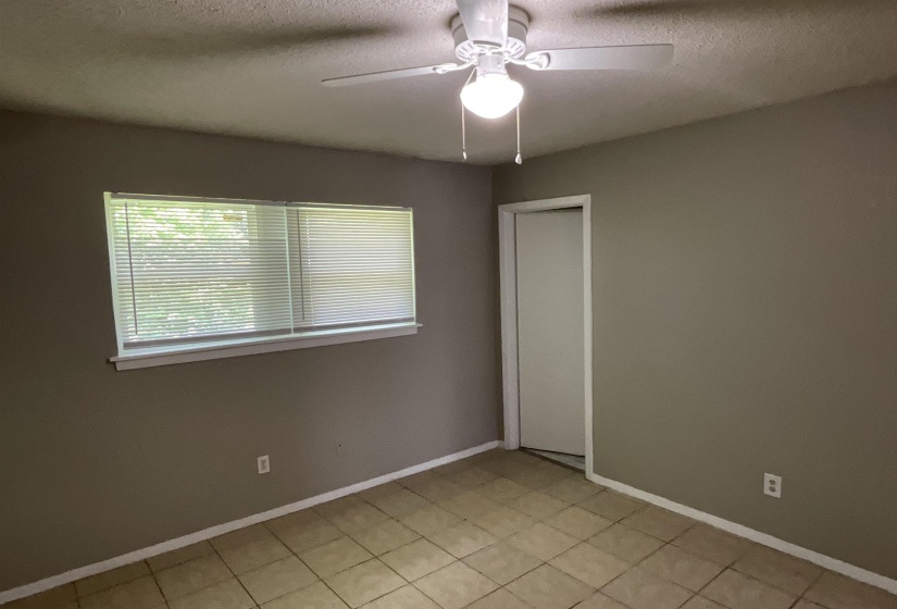 Spare room with a ceiling fan, a textured ceiling, and baseboards