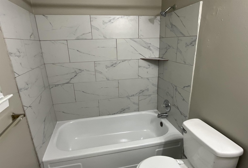 Full bathroom with toilet and tub / shower combination