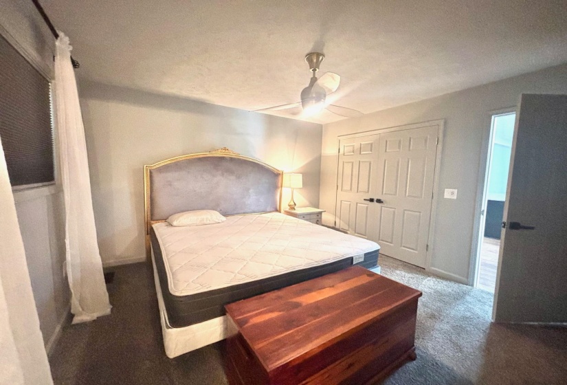 Bedroom with carpet floors, baseboards, a ceiling fan, and a large reach-in closet and ensuite bath