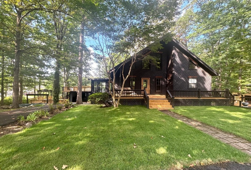 Rear view of house featuring a deck and a lawn