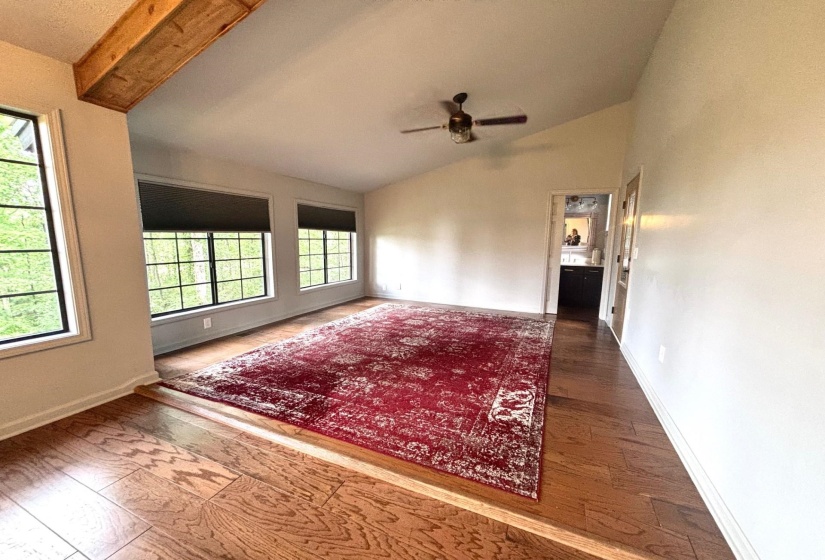 Unfurnished room featuring vaulted ceiling, ceiling fan, wood finished floors, and baseboards