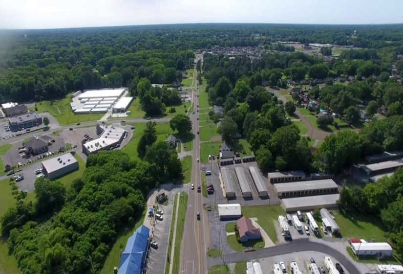 Aerial view of property and surrounding area featuring a forest