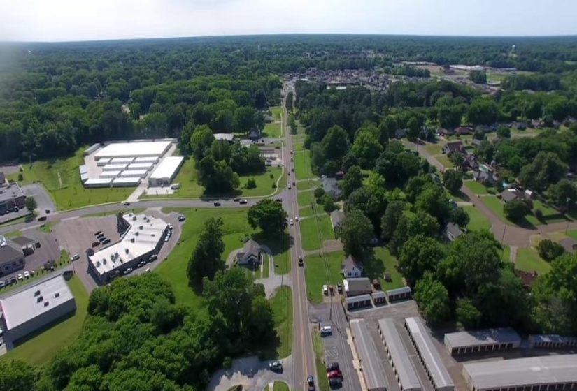 Aerial overview of property's location with a heavily wooded area