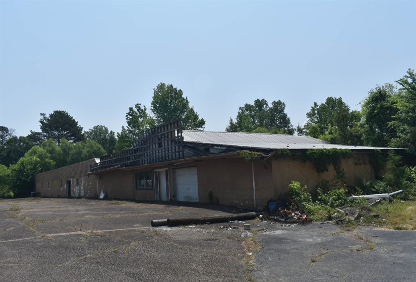 View of side of home with an attached garage and metal roof