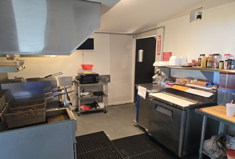 Kitchen featuring washer / dryer, concrete flooring, and vaulted ceiling