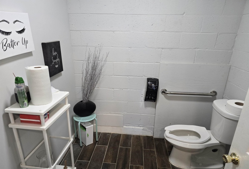 Half bath with toilet and wood finished floors