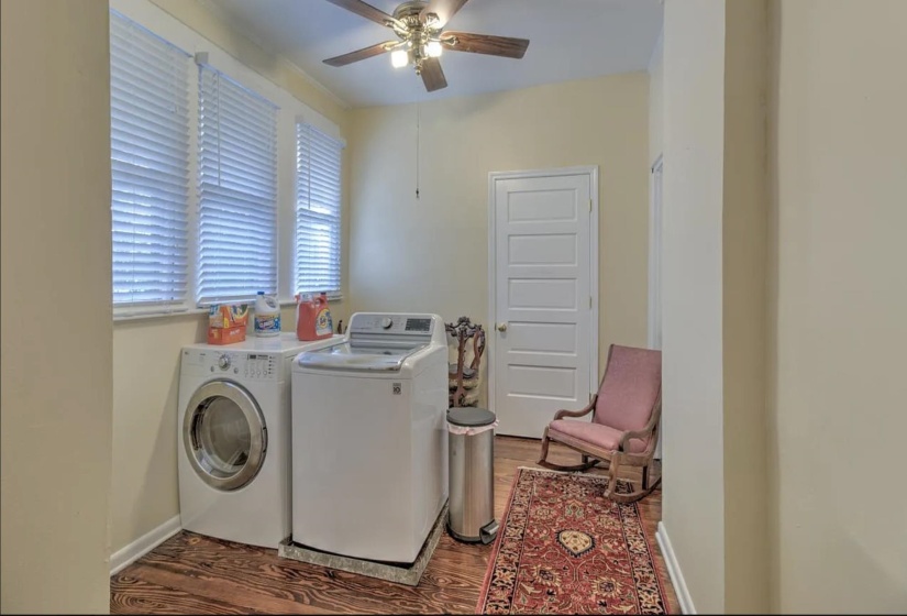 Laundry room featuring independent washer and dryer, a ceiling fan, wood finished floors, and baseboards