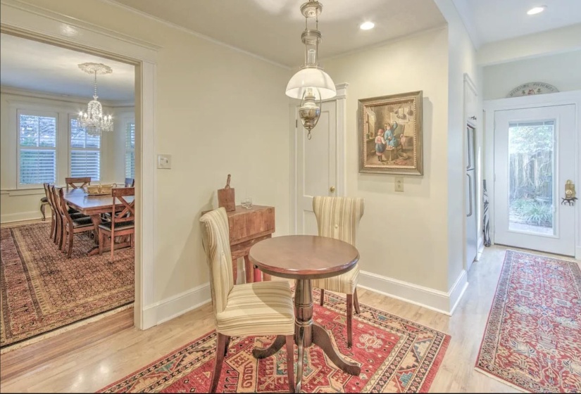 Dining space featuring a chandelier, light wood-type flooring, baseboards, and crown molding