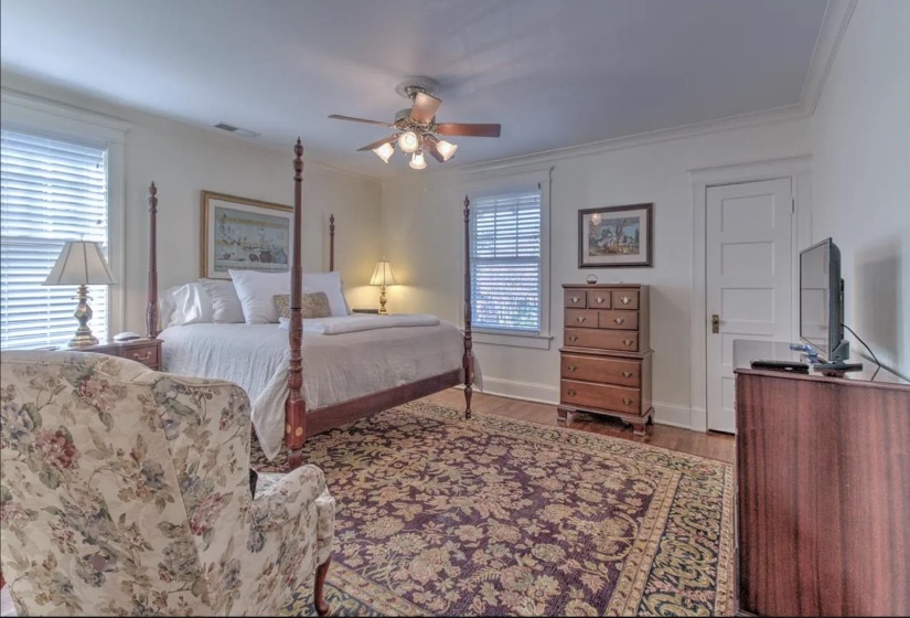 Bedroom featuring wood finished floors, ornamental molding, a ceiling fan, and baseboards