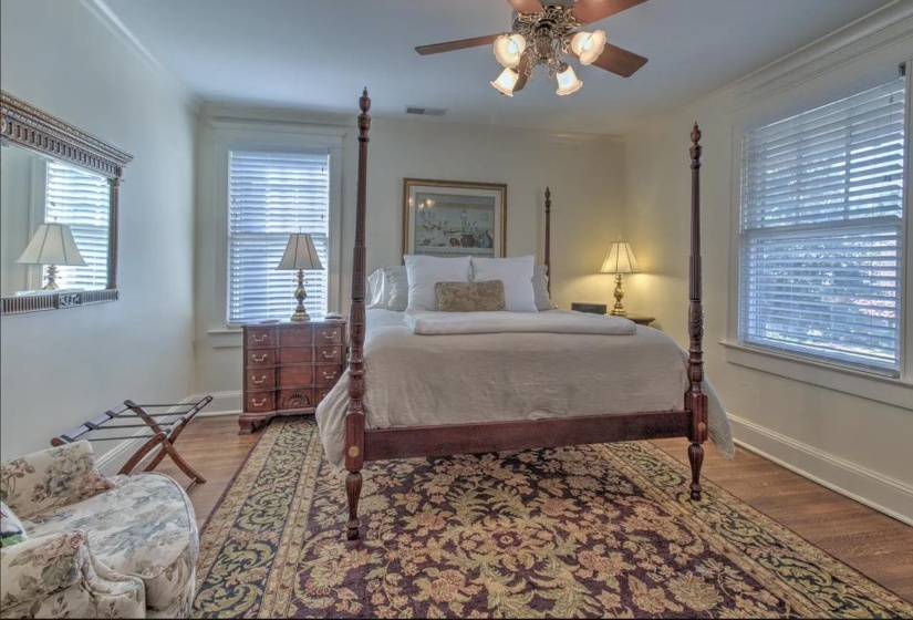Bedroom with ornamental molding, wood finished floors, ceiling fan, and baseboards