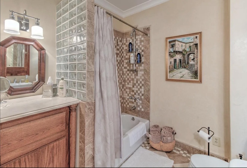 Bathroom with shower / bathtub combination with curtain, vanity, toilet, and crown molding