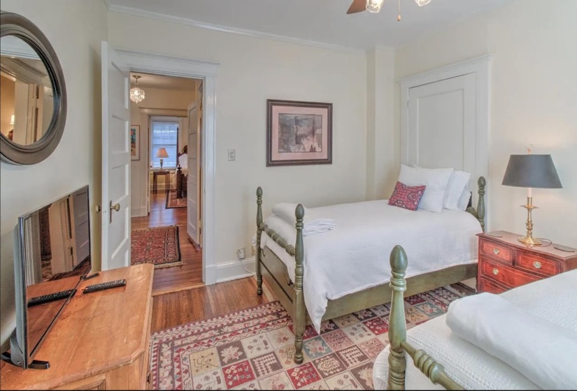 Bedroom featuring wood finished floors, ornamental molding, baseboards, and ceiling fan