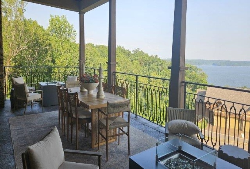 View of patio / terrace featuring an outdoor fire pit, outdoor dining space, and a wooded view