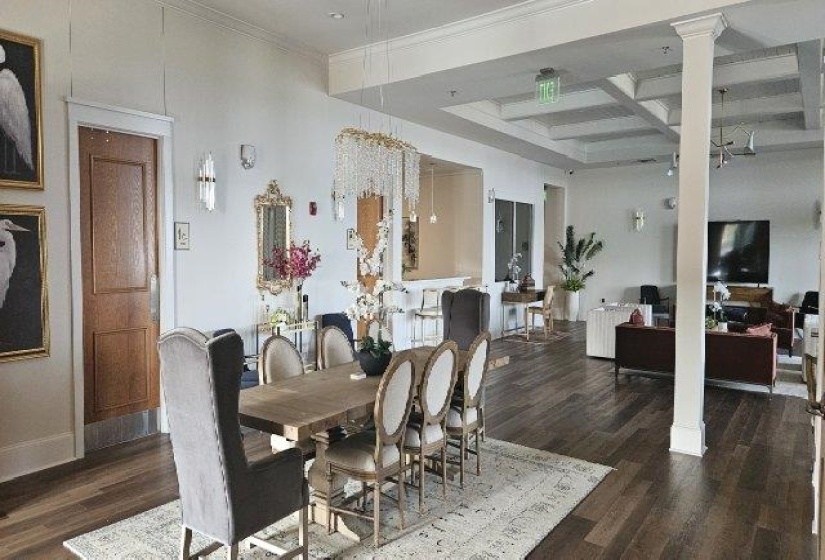 Dining space with coffered ceiling, wood finished floors, beam ceiling, ornate columns, and baseboards