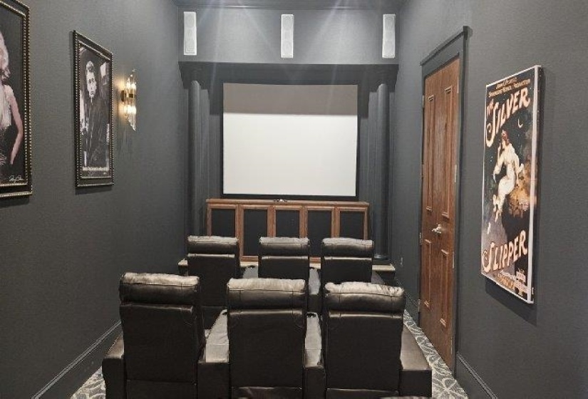 Carpeted home theater room with baseboards