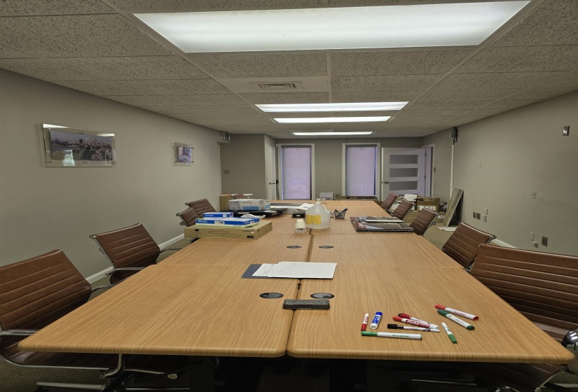 Conference room featuring a drop ceiling and baseboards