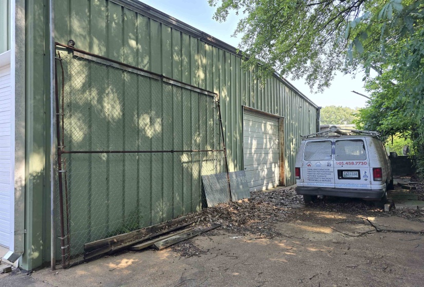 View of home's exterior featuring board and batten siding, an outbuilding, and a garage