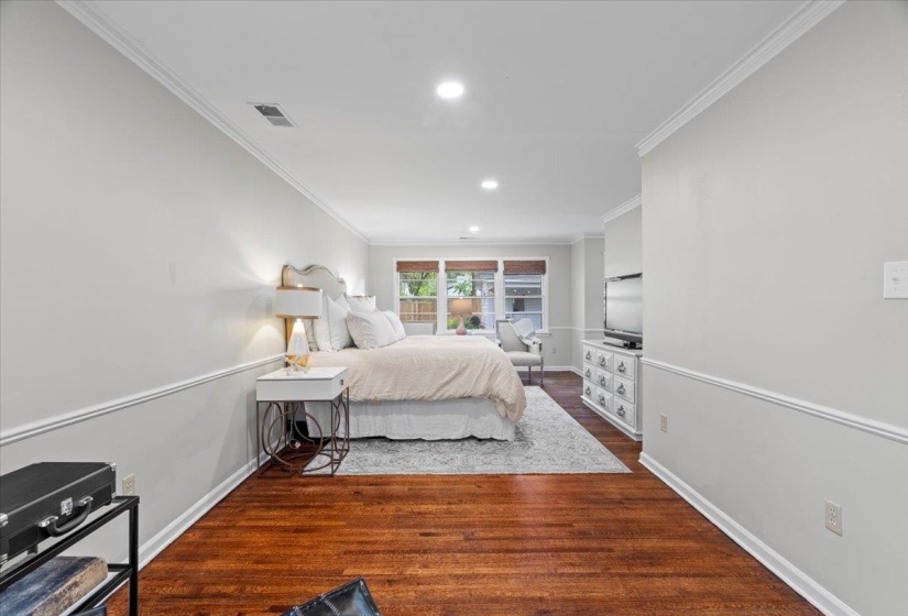Bedroom featuring ornamental molding, recessed lighting, baseboards, and wood finished floors