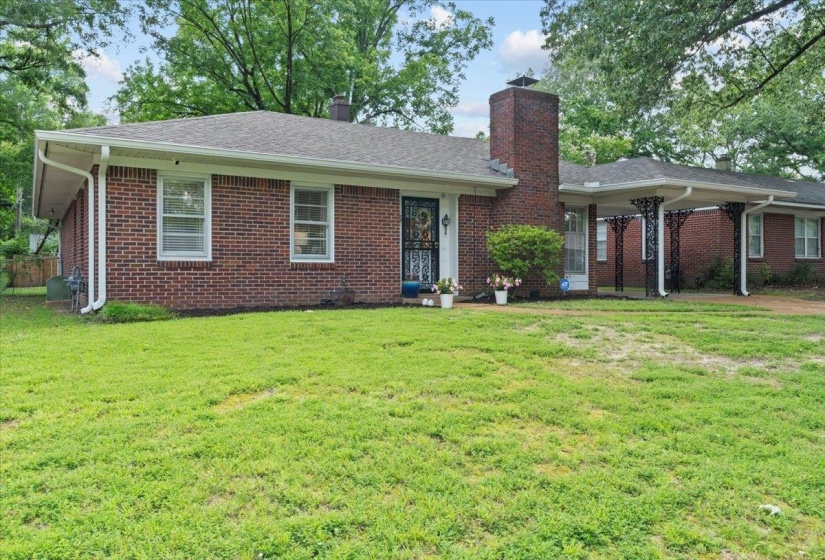 Ranch-style home featuring a chimney, a front yard, brick siding, and a shingled roof